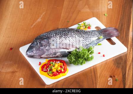 Roher Tilapia-Fisch auf einem Schneidebrett Stockfoto