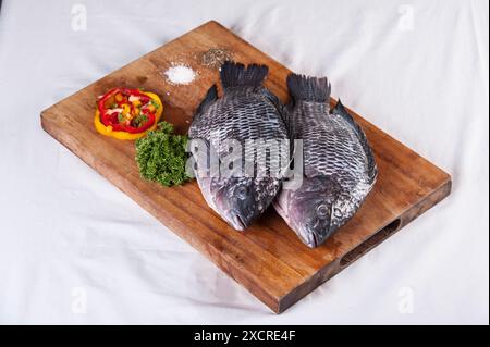 Roher Tilapia-Fisch auf einem Schneidebrett Stockfoto