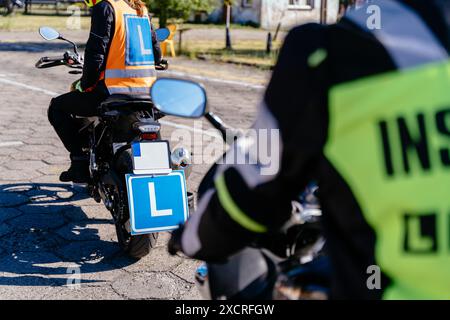 Zwei Leute fahren Motorräder mit den Buchstaben L und I auf ihrer Jacke. Einer der Fahrer trägt eine reflektierende Weste Stockfoto