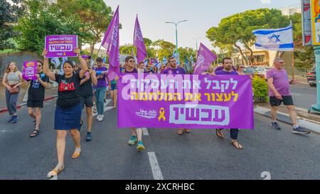 Haifa, Israel - 15. Juni 2024: Die Menschen nehmen an einem protestmarsch Teil, mit verschiedenen Zeichen und Fahnen, die den Krieg stoppen Stockfoto