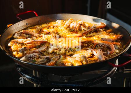 An einem sonnigen Tag kochen Sie traditionelle Meeresfrüchte und Hühnerpaella im Hinterhof Stockfoto