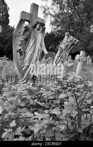 Schwarz-weißer Steinengelgrabmarker mit beschädigtem Arm auf dem Friedhof. Stockfoto