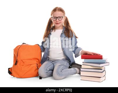 Lächelndes kleines Mädchen mit Büchern und Rucksack auf weißem Hintergrund Stockfoto