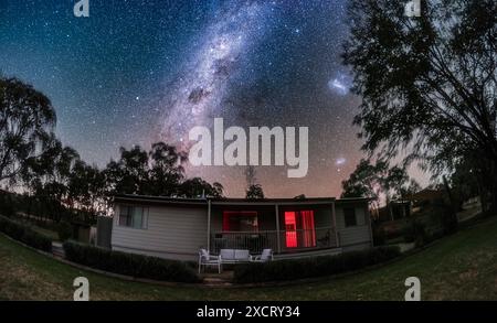 Dies ist die südliche Milchstraße in Carina, Crux und Centaurus, die sich über Mirrabook Cottage in der Nähe von Coonabarabran, NSW, Australien, erstreckt. Rechts sind die großen Stockfoto