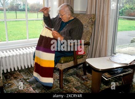 Wohnheim für ältere Menschen Watermoor House, Cirencester, Gloucestershire. Eine ältere Frau strickt, eine Decke für ein Haus von Mutter Teresa in Indien. November 1991 1990: HOMER SYKES Stockfoto