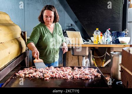 Die historische Schlägerin und Schiffseignerin Anne kocht in einer alten Werftküche ein Surina-Gericht/Wrap für ihre Bewohner aus der Nachbarschaft. Rotterdam, Niederlande. Stockfoto