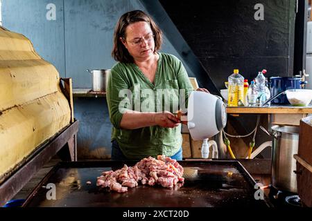 Die historische Schlägerin und Schiffseignerin Anne kocht in einer alten Werftküche ein Surina-Gericht/Wrap für ihre Bewohner aus der Nachbarschaft. Rotterdam, Niederlande. Stockfoto