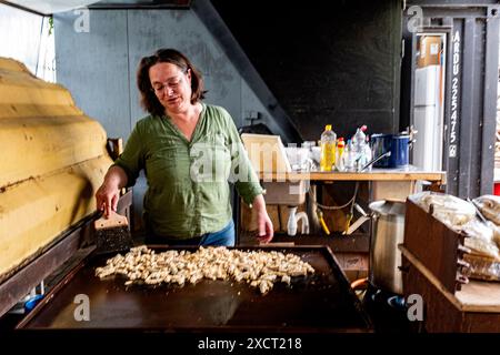 Die historische Schlägerin und Schiffseignerin Anne kocht in einer alten Werftküche ein Surina-Gericht/Wrap für ihre Bewohner aus der Nachbarschaft. Rotterdam, Niederlande. Stockfoto