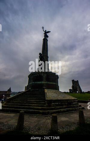 Das Denkmal für den Weltkrieg in Aberystwyth bei Sonnenaufgang mit den Ruinen der mittelalterlichen Burg im Hintergrund Stockfoto