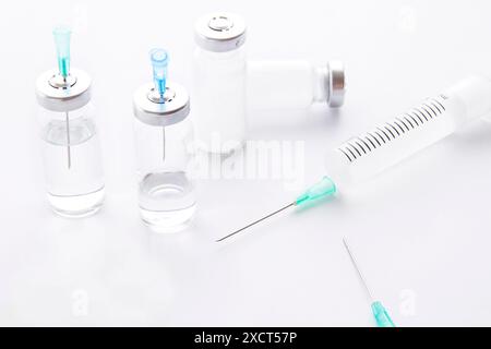 Spritze, Nadel, gelbe Tabletten und Arzneimittelflasche auf hellem Hintergrund Stockfoto