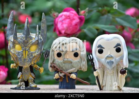 Funko Pop Actionfiguren von Sauron, Gandalf der Grau und Saruman der Weiße aus dem Fantasy-Film der Herr der Ringe. Moody Garden, rote Rosen. Stockfoto