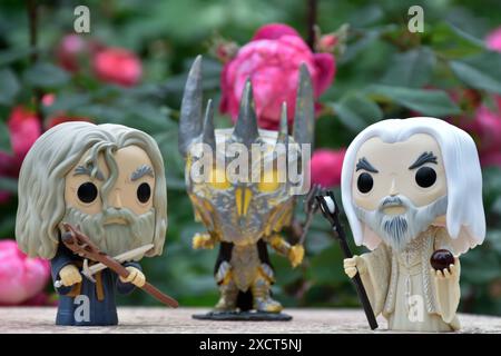 Funko Pop Actionfiguren von Gandalf dem Graen, Sauron und Saruman dem Weißen aus dem Fantasy-Film der Herr der Ringe. Geheimnisvoller Garten, rote Rosen. Stockfoto