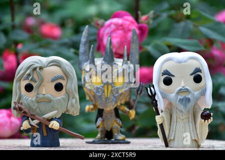 Funko Pop Actionfiguren von Gandalf dem Graen, Sauron und Saruman dem Weißen aus dem Fantasy-Film der Herr der Ringe. Geheimnisvoller Garten, rote Rosen. Stockfoto