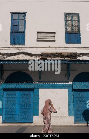 Tunis, Tunesien. Mai 2024. Ein Moslem, der ein Handy benutzt, läuft an der traditionellen blauen Architektur in der Madina der tunesischen Hauptstadt Tunis vorbei. (Foto: John Wreford/SOPA Images/SIPA USA) Credit: SIPA USA/Alamy Live News Stockfoto