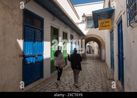 Tunis, Tunesien. Mai 2024. Zwei junge tunesische Frauen spazieren durch die traditionell geschmückten engen Gassen von Tunis Medina. (Foto: John Wreford/SOPA Images/SIPA USA) Credit: SIPA USA/Alamy Live News Stockfoto