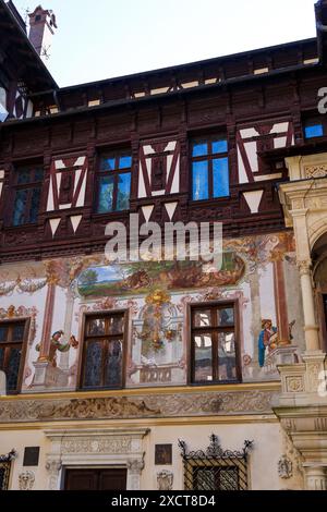 Die Innenhoffassaden des Schlosses Peles, die allegorische handgemalte Wandmalereien aufweisen und mit Fachwerk verziert sind. Die Stadt Sinaia, Karpaten, Rumänien. Stockfoto