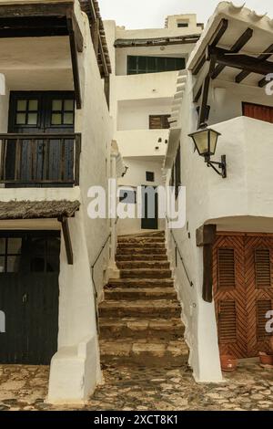 Malerischer Blick auf die traditionellen weiß getünchten Häuser und engen, verwinkelten Gassen von Binibeca Vell, Menorca. Stockfoto