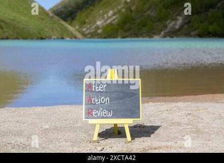 Symbol „AAR nach Aktion prüfen“. Konzeptworte AAR nach Aktionsrezension auf schöner gelber Tafel. Wunderschöner Bergsee im Hintergrund. Geschäftswert Stockfoto