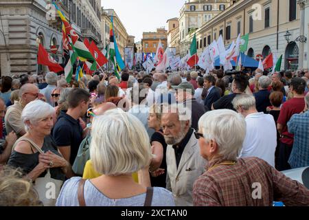 18. Juni 2024, Rom, Italien: Während der Demonstration, die von Oppositionsparteien aufgerufen wurde, gegen die Verfassungsreformen der Regierung Meloni in Rom zu protestieren, hören die Menschen Reden von der Bühne. Einige hundert Menschen versammelten sich auf der Piazza Santi Apostoli in Rom unter dem Motto „Lasst uns die nationale Einheit verteidigen“ anlässlich der von den Oppositionsparteien (Demokratische Partei, 5-Sterne-Bewegung, Grüne und Linke Allianz und mehr Europa) organisierten Demonstration der Einheit. um die Ablehnung der heute im Senat verabschiedeten Verfassungsreform des Premierministers und gegen die Differenzierten zum Ausdruck zu bringen Stockfoto