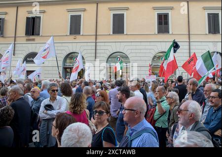 18. Juni 2024, Rom, Italien: Während der Demonstration, die von Oppositionsparteien aufgerufen wurde, gegen die Verfassungsreformen der Regierung Meloni in Rom zu protestieren, hören die Menschen Reden von der Bühne. Einige hundert Menschen versammelten sich auf der Piazza Santi Apostoli in Rom unter dem Motto „Lasst uns die nationale Einheit verteidigen“ anlässlich der von den Oppositionsparteien (Demokratische Partei, 5-Sterne-Bewegung, Grüne und Linke Allianz und mehr Europa) organisierten Demonstration der Einheit. um die Ablehnung der heute im Senat verabschiedeten Verfassungsreform des Premierministers und gegen die Differenzierten zum Ausdruck zu bringen Stockfoto