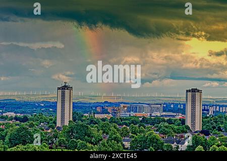 Glasgow, Schottland, Großbritannien. 18. Juni 2024: UK Weather: Feuchter und heißer sonniger Tag in der Stadt sah seltsamen Himmel mit einem Regenbogen über den Türmen von Scotstoun und dem Queen elizabeth Hospital; Credit Gerard Ferry/Alamy Live News Stockfoto