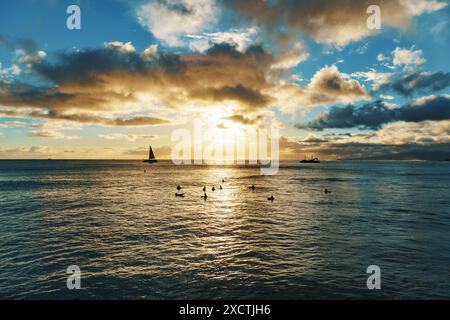 Eine Gruppe von Menschen genießt einen Sonnenuntergang und schwimmt gemeinsam im Meer Stockfoto