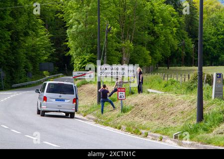 Die Leute hielten am Straßenrand in roncesvalles an, um Fotos von einem Schild auf dem Jakobsweg zu machen, auf dem „Santiago de Compostela 790 km“ steht Stockfoto