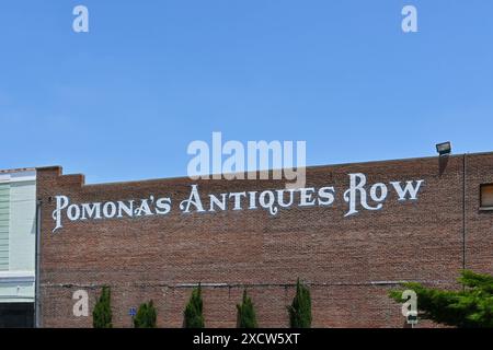 POMONA, KALIFORNIEN - 18. MAI 2024: Schild Pomonas Antique Row auf einem Backsteingebäude in der historischen Innenstadt von Pomona. Stockfoto