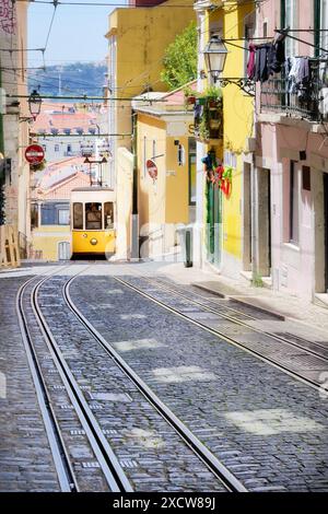 Ein Auto der Seilbahn Elevador da Bica in Lissabon fährt den Hügel in den engen Altstadtstraßen von lissabon hinauf Stockfoto