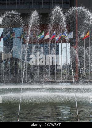 Wien, Österreich, Österreich. Juni 2024. Der Brunnen wurde für den Sommer bei den Vereinten Nationen in Wien wieder aufgezogen. Hier kann man sie mit der Flaggenreihe im Hintergrund durch das Wasser sehen. (Kreditbild: © Bianca Otero/ZUMA Press Wire) NUR REDAKTIONELLE VERWENDUNG! Nicht für kommerzielle ZWECKE! Stockfoto