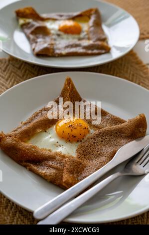 Galettes-Pfannkuchen aus der Bretagne mit Buchweizenmehl, serviert mit herzhaften Toppings, Schmelzkäse und Eiern aus nächster Nähe Stockfoto