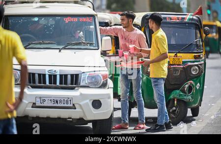 Neu-Delhi, Indien. Juni 2024. NEW DELHI, INDIEN - 18. JUNI: Die Einheimischen verteilen Sharbat (Süßwasser) an Pendler, die an einem heißen Sommertag in Laxmi Nagar am 18. Juni 2024 in Neu-Delhi vorbeifahren. (Foto: Raj K Raj/Hindustan Times/SIPA USA) Credit: SIPA USA/Alamy Live News Stockfoto