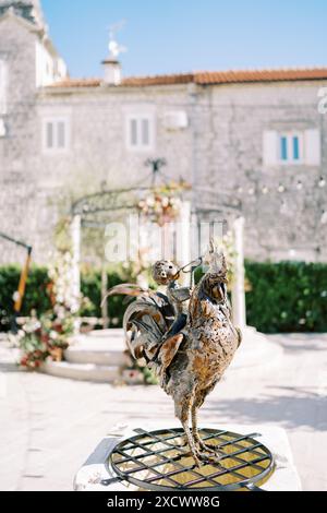 Skulptur eines Bugler-Jungen, der auf einem Hahn im Innenhof eines alten Hauses reitet Stockfoto