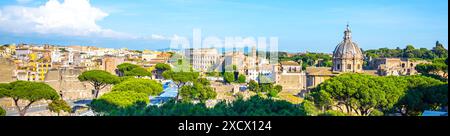 Panoramablick auf das Forum Romanum und das Kolosseum in Rom, Italien. Die antiken Ruinen sind von üppigem Grün umgeben, was einen eindrucksvollen Kontrast zwischen Geschichte und Natur schafft. Stockfoto