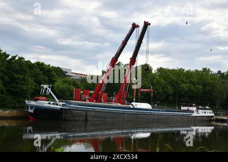 Ein Hochdruck-Gasabscheider, den die Firma Leffer i8n Dudweiler gebaut hat, wird am Dienstag 18.6.2024 an der Roro-Verladestelle der Saar in Saarbrücken mit Schwerlastkränen in einem Schiff gehoben. Die 175,85 Tonnen schwere Anlage wird nach Norwegen verschifft und lag mehrere Tage an der Saar wir berichteten. Das saarländische Familienunternehmen Leffer aus Dudweiler, ein Weltkonzern für den Stahl- und Apparatebau, hat den Abscheider mit einem Schwertransport zur Saar gebracht, jetzt geht es es es über Wasserstraßen weiter zum Ziel. Der Reaktor war mehrere Tage bewacht worden, um Vandalismus zu verhi Stockfoto