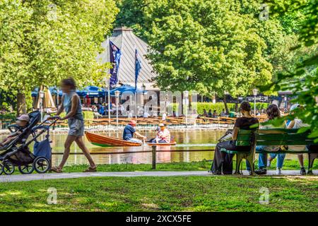 Sommer, Sonne, Freizeit im Englischen Garten, Temperaturen schnellen hoch auf 30 Grad, München, Juni 2024 Deutschland, München, Juni 2024, Sommer, Sonne, Freizeit im Englischen Garten, Rekordtemperaturen bis 30 Grad, Spazierengehen, ausruhen, lesen im Schatten am Seeufer, Boot fahren auf dem Kleinhesseloher See, im Hintergrund das Seehaus mit Biergarten, Bayern *** Sommer, Sonne, Freizeit im Englischen Garten, Temperaturen steigen auf 30 Grad, München, Juni 2024 Deutschland, München, München, Juni 2024, Sommer, Sonne, Freizeit im Englischen Garten, Temperaturaufzeichnung von bis zu 30 Grad, Wandern, Entspannen Stockfoto