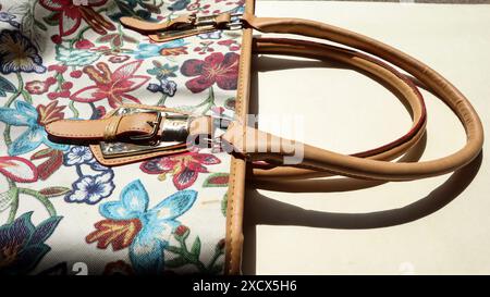Handtasche mit mehrfarbigem Blumenmuster und Griff mit Schnallengürtel Stockfoto