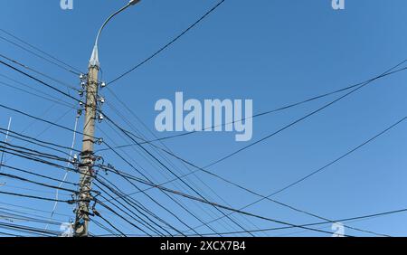 Viele Kabel und Drähte an einem elektrischen Pol. Stockfoto