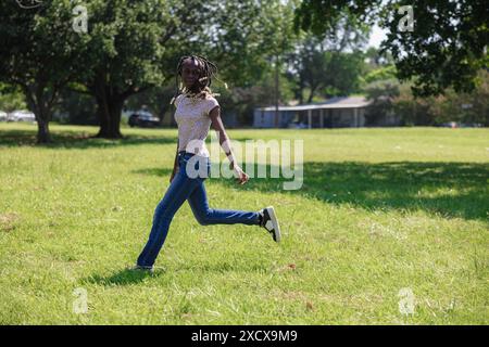 Ein Kind, das am Family Field Day in Fort Worth, Texas, im Freien auf grünem Gras spielt Stockfoto