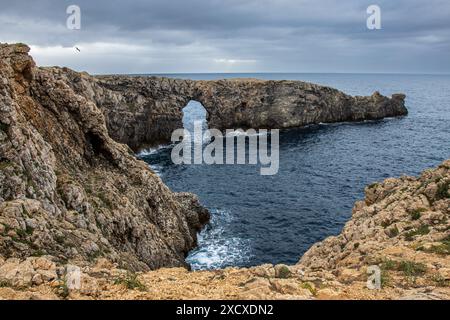 Pont de Gil, histórico puente de piedra que salva un barranco. Puente, naturaleza y horizonte marino crean una imagen de armonía. Menorca, España Stockfoto