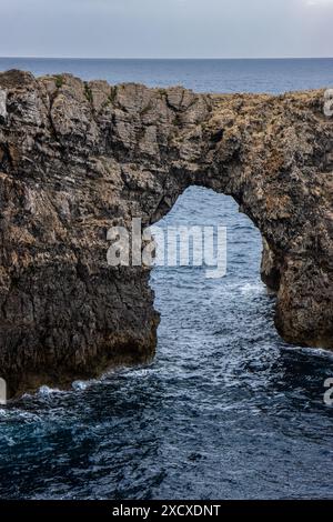 Pont de Gil, histórico puente de piedra que salva un barranco. Puente, naturaleza y horizonte marino crean una imagen de armonía. Menorca, España Stockfoto