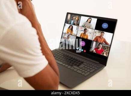 Mann, der an einer Videokonferenz mit verschiedenen Gruppen von Menschen teilnimmt Stockfoto