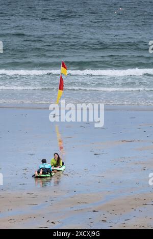 Ein Surfcoach von der Escape Surf School und ein Surflerner, der eine Surfstunde am Towan Beach in Newquay in Cornwall in Großbritannien absolviert. Stockfoto