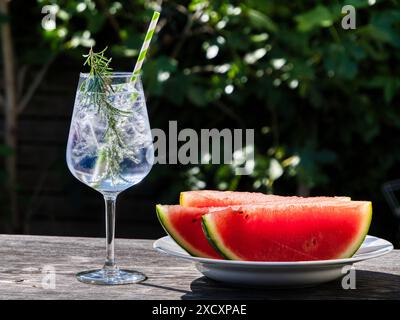Eine Nahaufnahme von Gin Tonic in einem Glas serviert mit Wassermelonen Stockfoto
