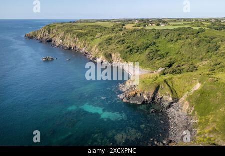 Ein Blick aus der Vogelperspektive auf Poltesco an der Südküste von Cornwall, England mit zerklüfteten Felsen und Klippen bis zum Meer. Stockfoto