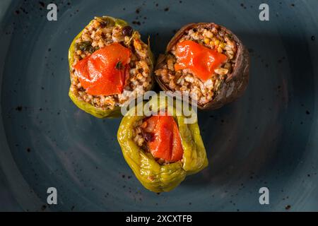 Gefüllte grüne Paprika und Auberginen mit Olivenöl auf Steintisch Stockfoto