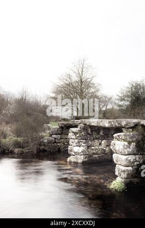 Die antike mittelalterliche „Clapper Bridge“ im kleinen Weiler Postbridge auf Dartmoor in Devon. Stockfoto