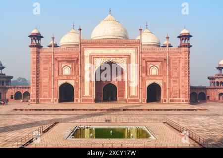 Die Kau Ban Moschee des Taj Mahal Komplexes auf blauem Himmel Hintergrund in Agra, Indien. Fantastisches Gebäude aus rotem Sandstein, das sich im Wasser des Pools spiegelt. Stockfoto