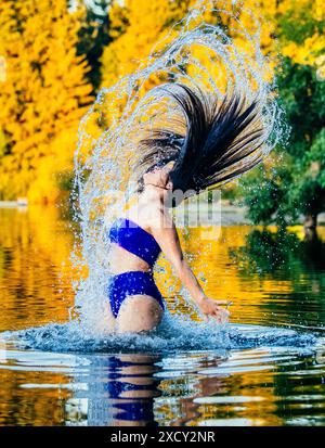 Langhaarige Frau, die im See planscht Stockfoto