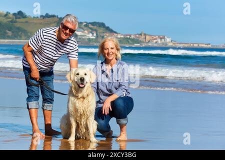 Seniorenpaar, 60-70, Spaziergang mit Hund am Strand, Hintergrund Getaria, Zarautz, Gipuzkoa, Baskenland, Spanien, Europa Stockfoto